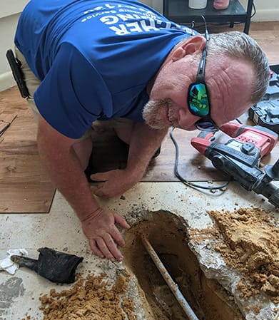 a plumber fixing a pipe in the ground