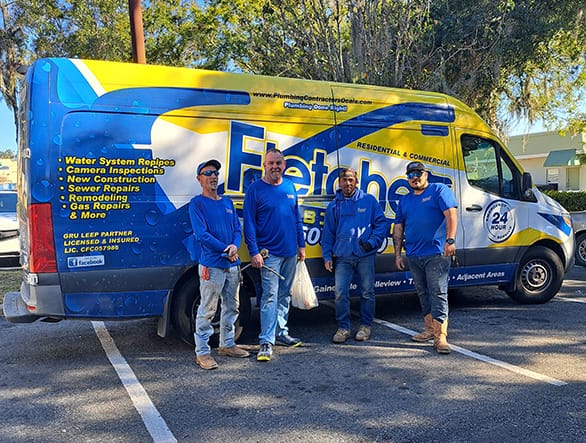 plumbers standing in front of truck